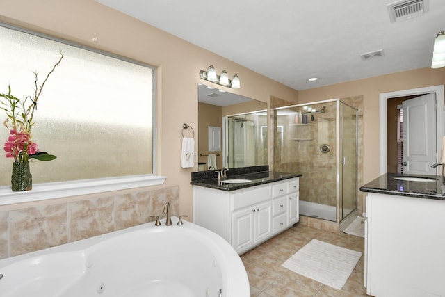 2640 Couch St, Houston, TX 77008 - full bathroom featuring two vanities, a stall shower, a jetted tub, and tile patterned floors