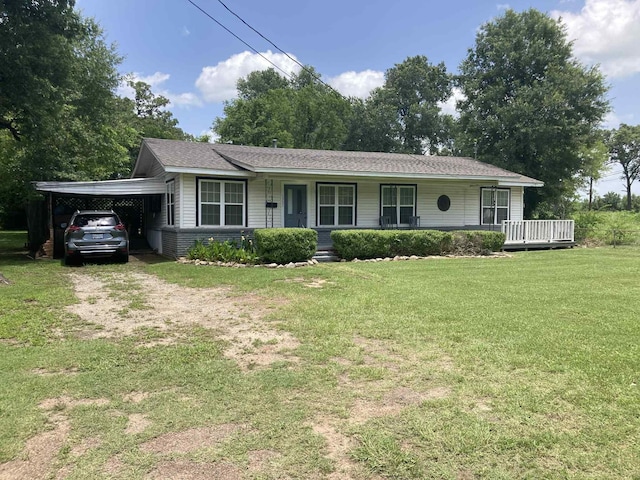 1305 E Goliad Ave, Crockett, TX 75835 - single story home with a porch, dirt driveway, a front yard, and an attached carport