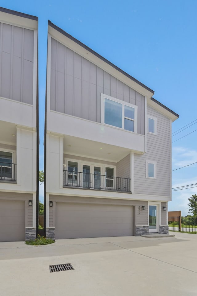 3913 Hare St, Houston, TX 77020 - view of front facade featuring stone siding, board and batten siding, a garage, and concrete driveway