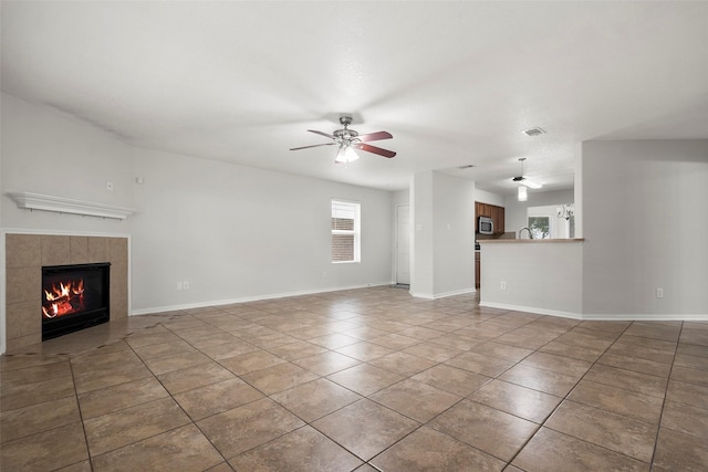 4838 Fair Oak Dale Ln, Humble, TX 77346 - unfurnished living room featuring tile patterned floors, ceiling fan, and a tiled fireplace