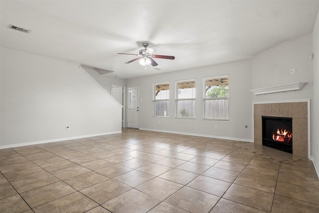 4838 Fair Oak Dale Ln, Humble, TX 77346 - unfurnished living room featuring a tile fireplace, a ceiling fan, and light tile patterned floors