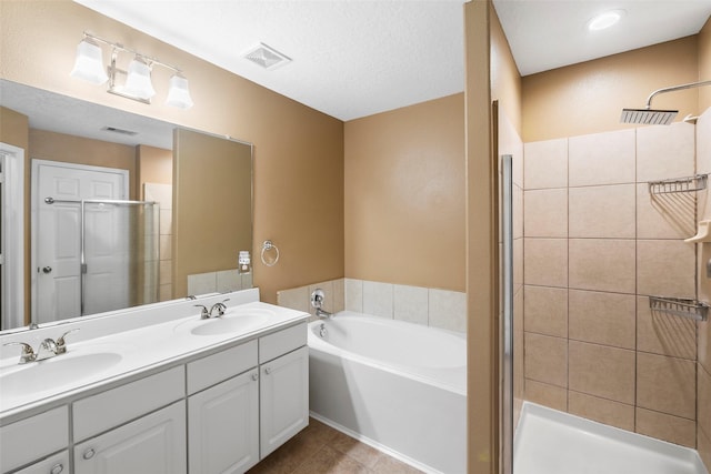 4838 Fair Oak Dale Ln, Humble, TX 77346 - bathroom featuring a stall shower, double vanity, a garden tub, tile patterned flooring, and a textured ceiling