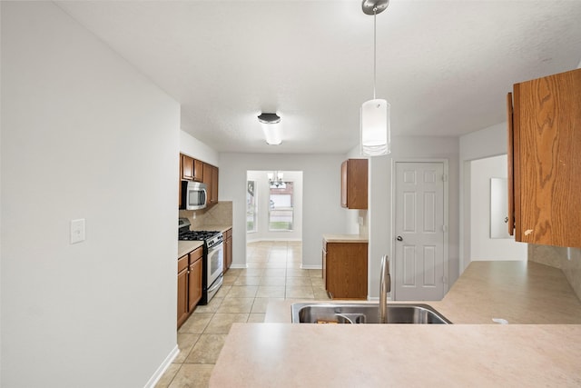 4838 Fair Oak Dale Ln, Humble, TX 77346 - kitchen featuring appliances with stainless steel finishes, brown cabinetry, light tile patterned floors, and decorative backsplash