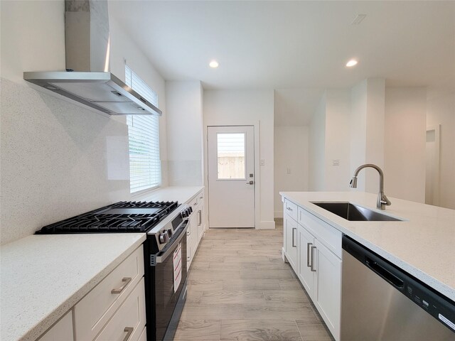 6735 Cohn St, Houston, TX 77091 - kitchen with appliances with stainless steel finishes, island range hood, healthy amount of natural light, white cabinetry, and recessed lighting