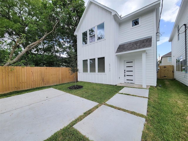 6735 Cohn St, Houston, TX 77091 - back of property with board and batten siding, a patio, and a shingled roof