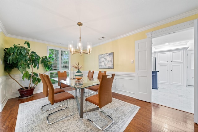 20234 Brondesbury Dr, Katy, TX 77450 - dining space with a chandelier, ornamental molding, wood finished floors, and wainscoting