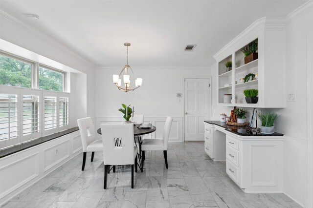 20234 Brondesbury Dr, Katy, TX 77450 - dining space featuring a decorative wall, a chandelier, crown molding, wainscoting, and light marble finish flooring