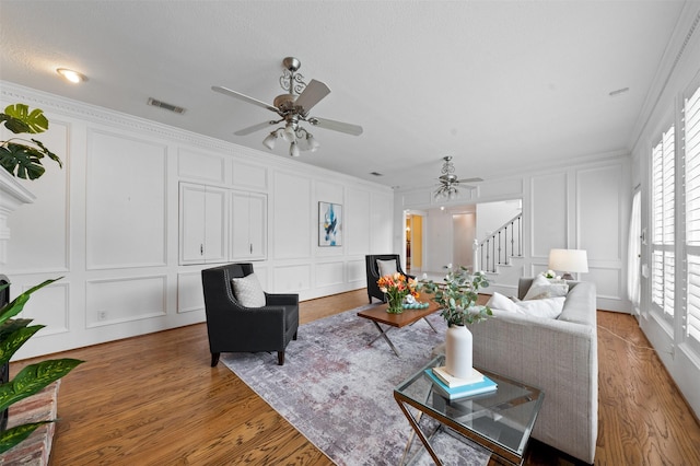 20234 Brondesbury Dr, Katy, TX 77450 - living room featuring a decorative wall, stairway, a ceiling fan, ornamental molding, and wood finished floors