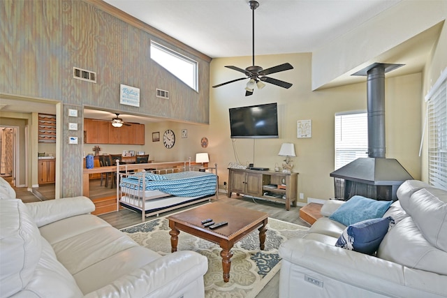 206 Galleon Dr, Freeport, TX 77541 - living area featuring a ceiling fan, a wood stove, high vaulted ceiling, and wood finished floors