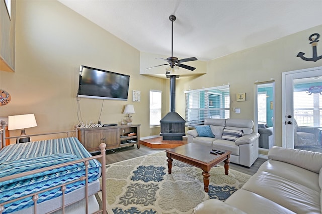 206 Galleon Dr, Freeport, TX 77541 - living room with wood finished floors, a wood stove, a ceiling fan, and vaulted ceiling