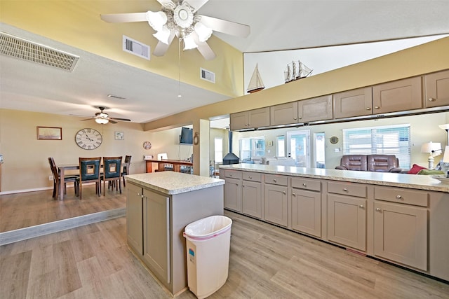 206 Galleon Dr, Freeport, TX 77541 - kitchen with a ceiling fan, gray cabinets, light wood-type flooring, light countertops, and a kitchen island