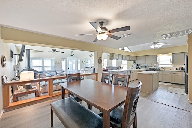 206 Galleon Dr, Freeport, TX 77541 - dining room with ceiling fan, light wood finished floors, plenty of natural light, and a textured ceiling