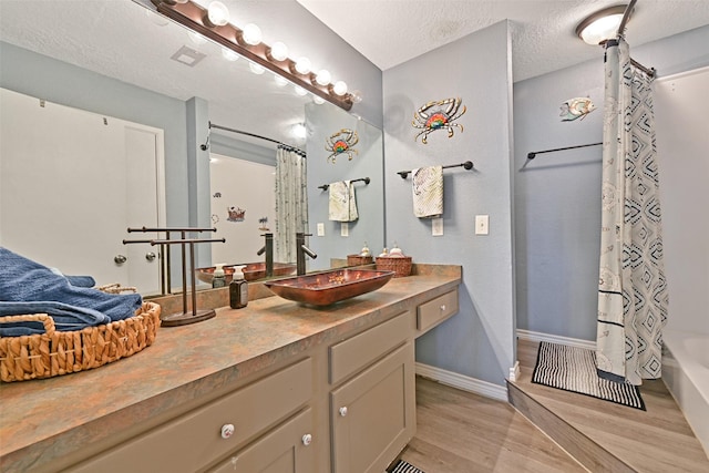 206 Galleon Dr, Freeport, TX 77541 - full bath featuring wood finished floors, vanity, a textured ceiling, and shower / tub combo