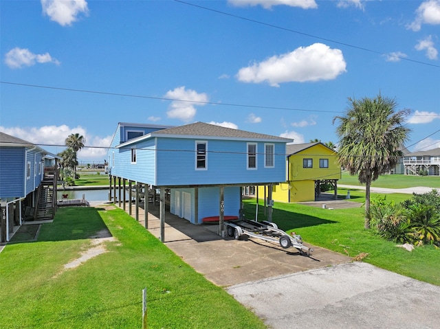 206 Galleon Dr, Freeport, TX 77541 - back of property with a carport, a lawn, driveway, stairway, and a water view