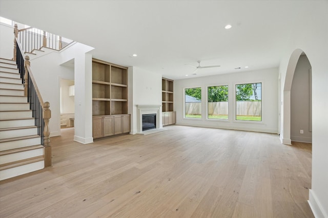2006 Chantilly Ln, Houston, TX 77018 - unfurnished living room featuring a ceiling fan, recessed lighting, a glass covered fireplace, stairway, and light wood-style floors