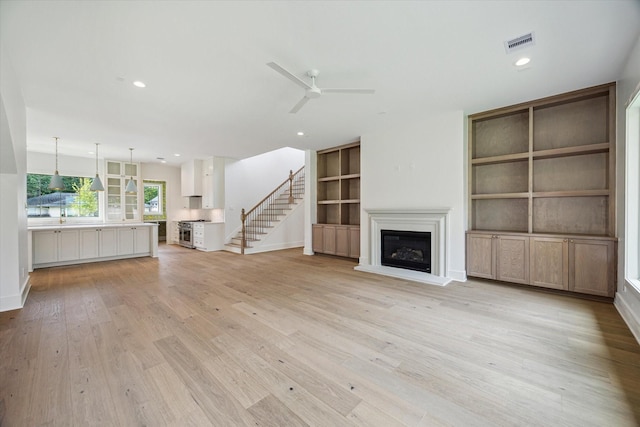 2006 Chantilly Ln, Houston, TX 77018 - unfurnished living room with ceiling fan, a glass covered fireplace, light wood-style floors, built in features, and recessed lighting