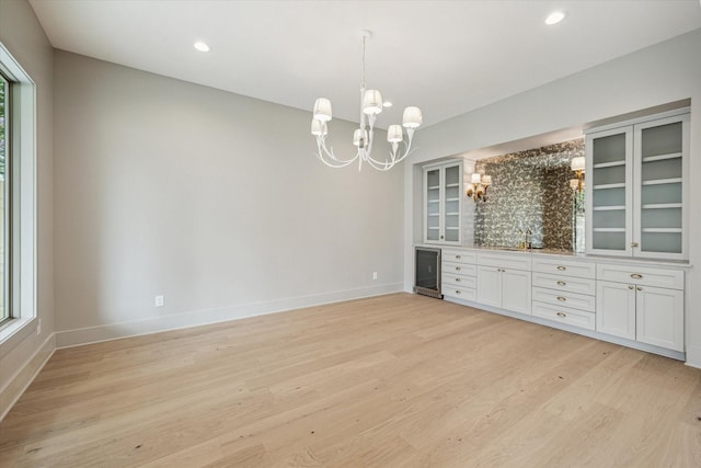 2006 Chantilly Ln, Houston, TX 77018 - spare room featuring a chandelier, light wood-style flooring, beverage cooler, recessed lighting, and bar area