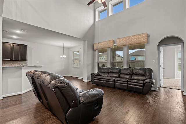 18514 Providence Landing Ln, Richmond, TX 77407 - living area featuring ceiling fan, a towering ceiling, dark wood-style floors, a chandelier, and arched walkways