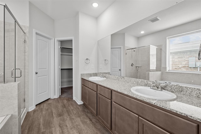 132 Big Sandy Ln, Anahuac, TX 77514 - full bath featuring a shower stall, wood finished floors, double vanity, and a walk in closet