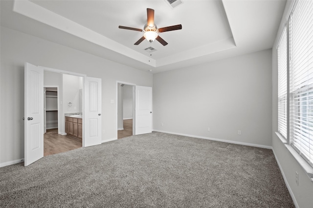 132 Big Sandy Ln, Anahuac, TX 77514 - unfurnished bedroom with light carpet, a raised ceiling, and a ceiling fan