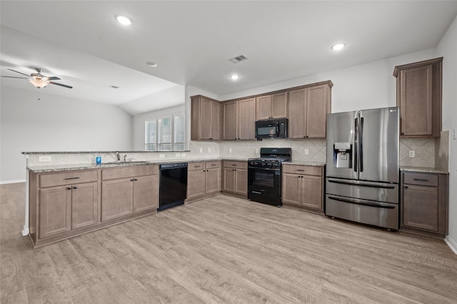132 Big Sandy Ln, Anahuac, TX 77514 - kitchen featuring black appliances, ceiling fan, light wood finished floors, a peninsula, and tasteful backsplash