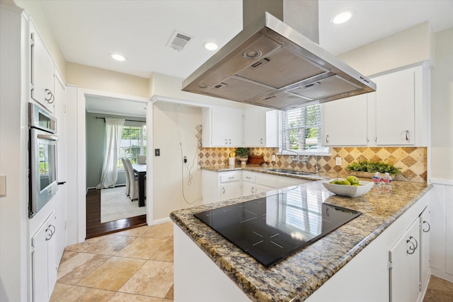 9222 Bronco Dr, Houston, TX 77055 - kitchen featuring extractor fan, black electric stovetop, stainless steel oven, white cabinets, and tasteful backsplash