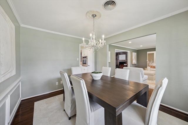 9222 Bronco Dr, Houston, TX 77055 - dining area featuring a chandelier, wood finished floors, crown molding, and recessed lighting