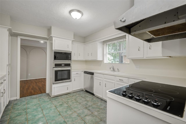 5330 Boyce Springs Dr, Houston, TX 77066 - kitchen with appliances with stainless steel finishes, range hood, white cabinets, open shelves, and light countertops