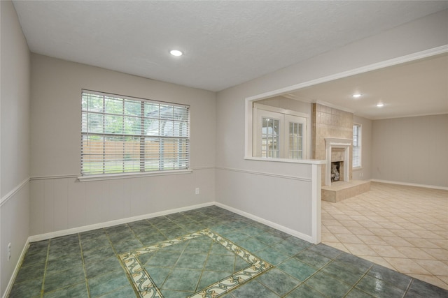 5330 Boyce Springs Dr, Houston, TX 77066 - empty room featuring a fireplace, recessed lighting, a wainscoted wall, and tile patterned flooring
