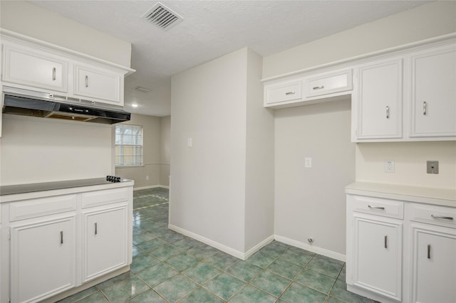 5330 Boyce Springs Dr, Houston, TX 77066 - kitchen featuring under cabinet range hood, black electric stovetop, white cabinetry, light countertops, and tile patterned flooring