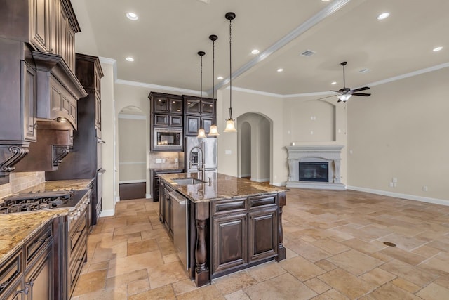20307 Knights Branch Dr, Cypress, TX 77433 - kitchen with arched walkways, appliances with stainless steel finishes, a ceiling fan, backsplash, and crown molding