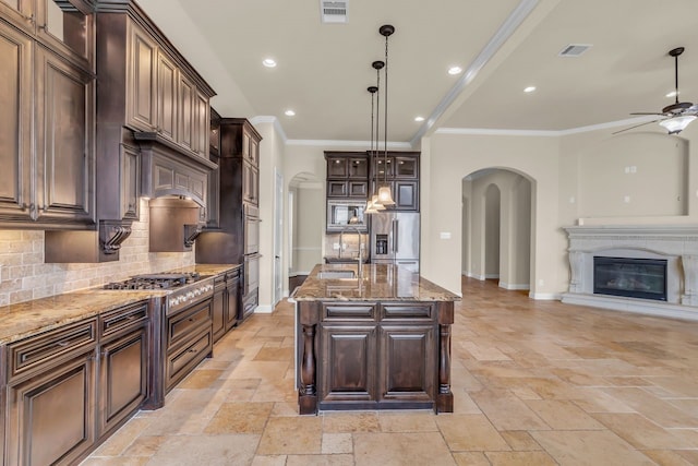 20307 Knights Branch Dr, Cypress, TX 77433 - kitchen featuring arched walkways, stainless steel appliances, ceiling fan, stone tile flooring, and recessed lighting