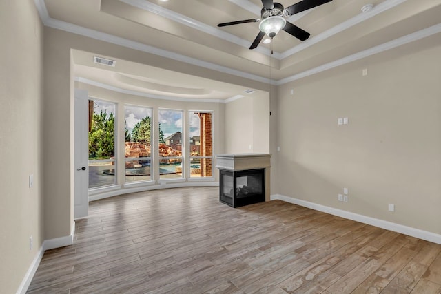 20307 Knights Branch Dr, Cypress, TX 77433 - unfurnished living room with a tray ceiling, crown molding, wood finished floors, a multi sided fireplace, and ceiling fan