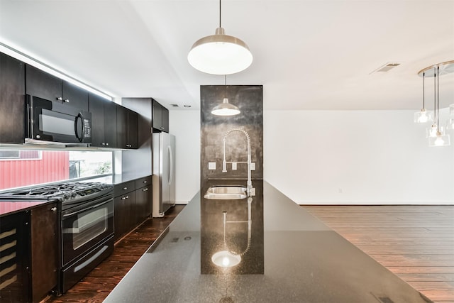 3028 Commerce St, Houston, TX 77003 - kitchen with black appliances, decorative light fixtures, dark countertops, and dark cabinetry