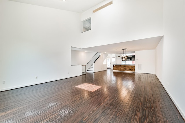 3028 Commerce St, Houston, TX 77003 - unfurnished living room with wood-type flooring, stairs, and a chandelier