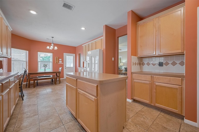 24922 Falcon Hollow Ln, Katy, TX 77494 - kitchen with white refrigerator with ice dispenser, a chandelier, backsplash, a center island, and light brown cabinetry