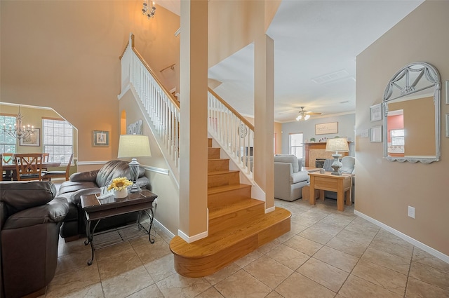 24922 Falcon Hollow Ln, Katy, TX 77494 - staircase featuring a tiled fireplace, healthy amount of natural light, a chandelier, and a ceiling fan