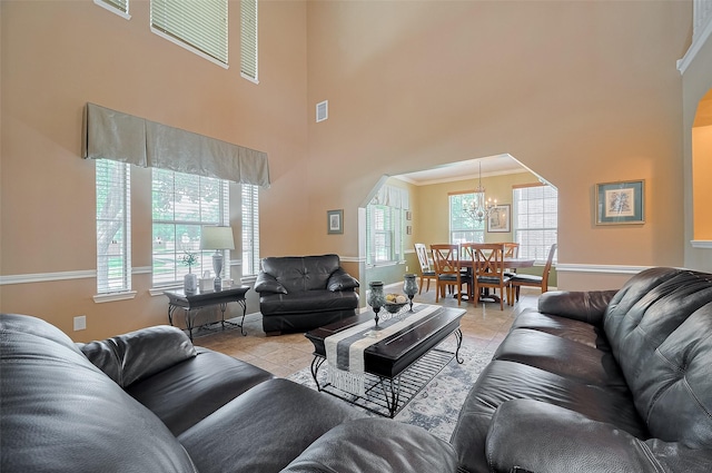 24922 Falcon Hollow Ln, Katy, TX 77494 - living room with a high ceiling, a chandelier, light tile patterned floors, and arched walkways