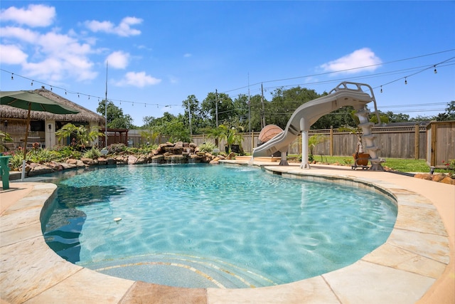 1201 Coryell St, League City, TX 77573 - view of pool featuring a water slide, a fenced backyard, and a patio area