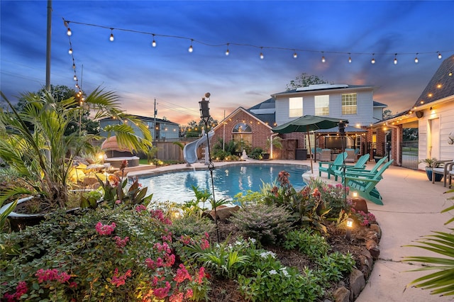 1201 Coryell St, League City, TX 77573 - view of swimming pool with a water slide, a fenced backyard, and a patio area