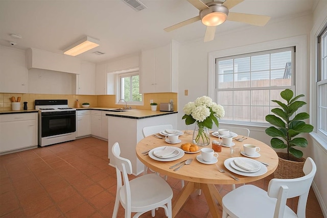826 Heights Blvd, Houston, TX 77007 - kitchen featuring white range, tasteful backsplash, white cabinetry, and a ceiling fan