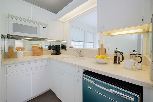826 Heights Blvd, Houston, TX 77007 - kitchen with white microwave, dishwashing machine, white cabinets, and light stone countertops