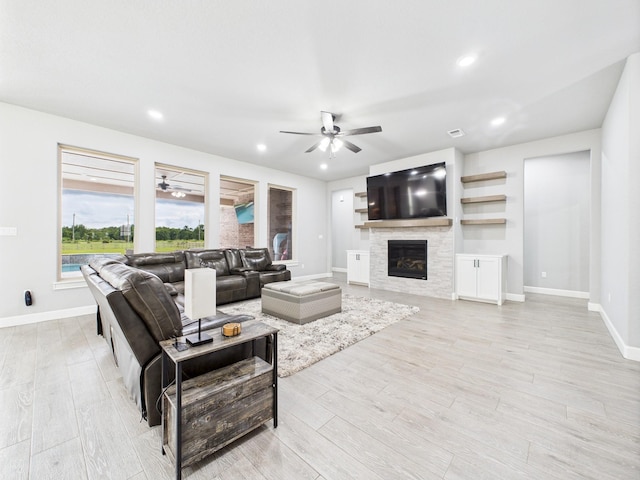 2711 Oakwood Shores Dr, Richwood, TX 77515 - living room featuring a ceiling fan, light wood-type flooring, a glass covered fireplace, and recessed lighting