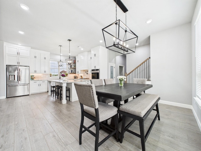 2711 Oakwood Shores Dr, Richwood, TX 77515 - dining area featuring a chandelier, light wood-type flooring, recessed lighting, and stairs
