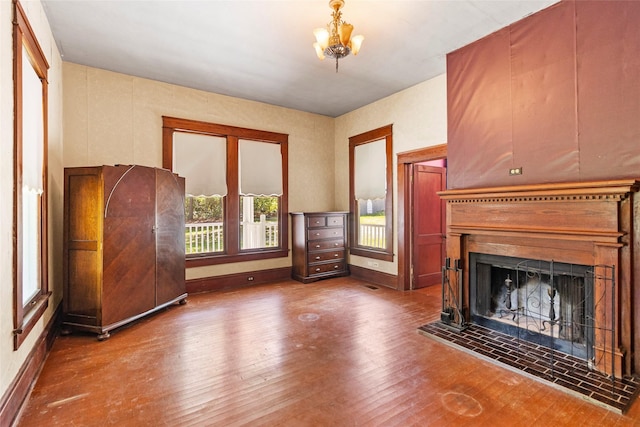 38 Darrell White Rd, Huntsville, TX 77340 - unfurnished living room with a fireplace with raised hearth, wood finished floors, and a chandelier