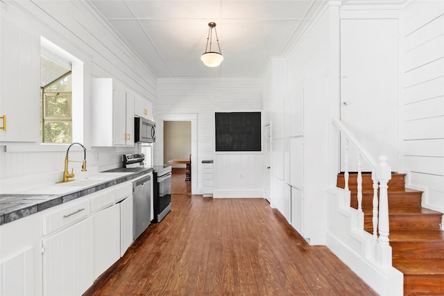 38 Darrell White Rd, Huntsville, TX 77340 - kitchen with appliances with stainless steel finishes, dark wood-style floors, white cabinets, pendant lighting, and a decorative wall