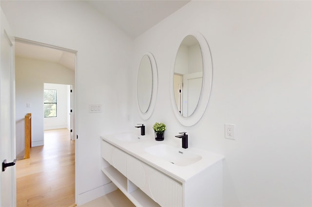 5055 Yarwell Dr, Houston, TX 77096 - bathroom featuring double vanity, wood finished floors, and vaulted ceiling