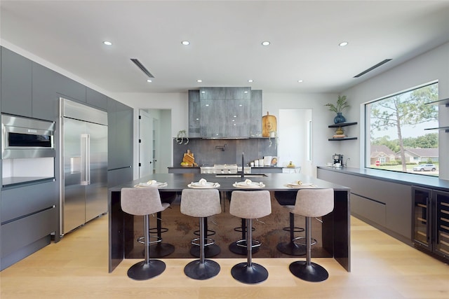 5055 Yarwell Dr, Houston, TX 77096 - kitchen with built in appliances, modern cabinets, light wood-style flooring, backsplash, and recessed lighting