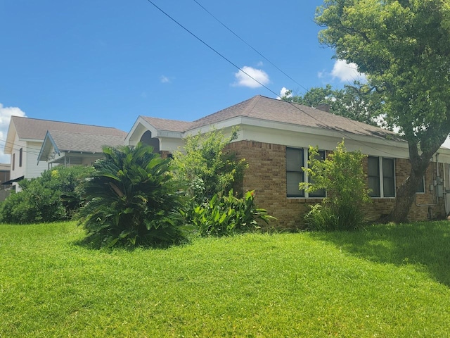 2301 45th St, Galveston, TX 77551 - view of home's exterior with brick siding and a yard