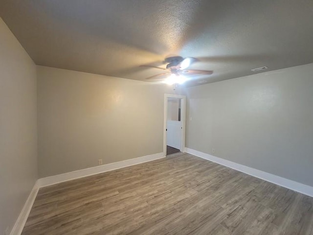 2301 45th St, Galveston, TX 77551 - empty room with a ceiling fan, wood finished floors, and a textured ceiling